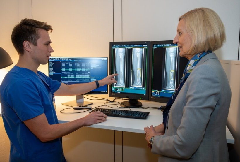 Dr. Jonathan van Dieken und Petra Oberthür stehen vor einem Tisch, auf dem...