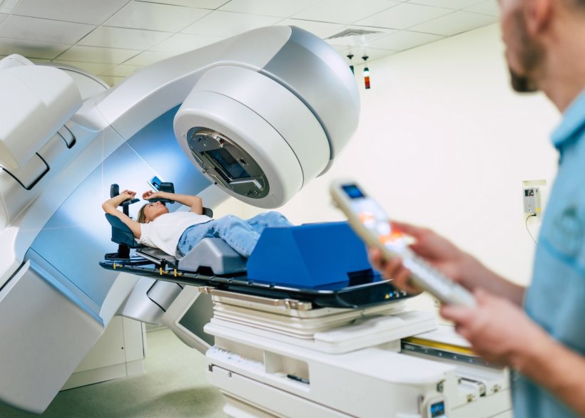 Eine Frau unterzieht sich in einer großen Maschine einer Strahlentherapie....