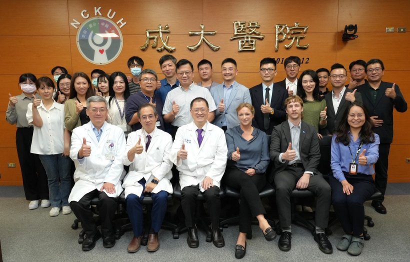Group photo in front of a wood panel wall with the Chinese lettering...