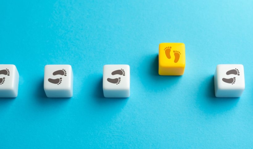 Eine horizontale Reihe weißer Würfel mit Fußabdrücken, die alle in die...