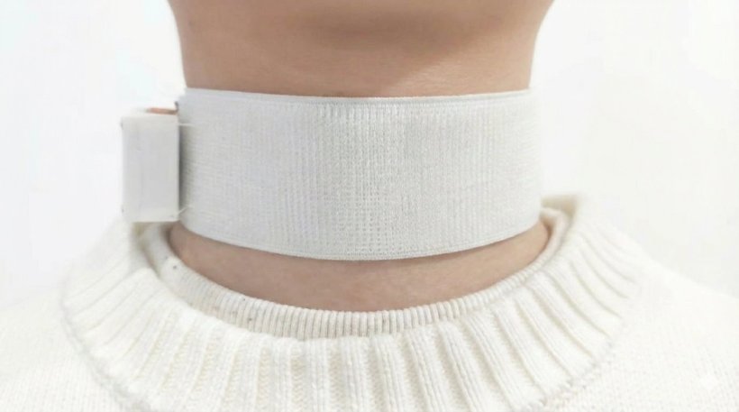 Closeup photo of a persons neck with a white choker