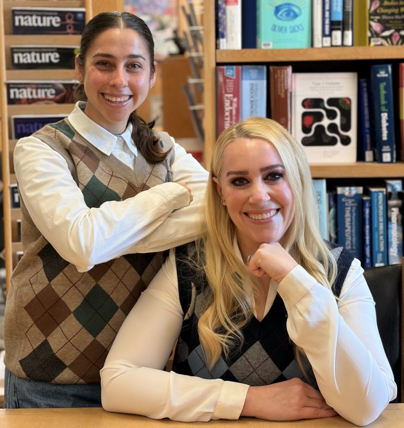 Karina Sanchez and Janelle Ayres are standing and sitting in a universitys...