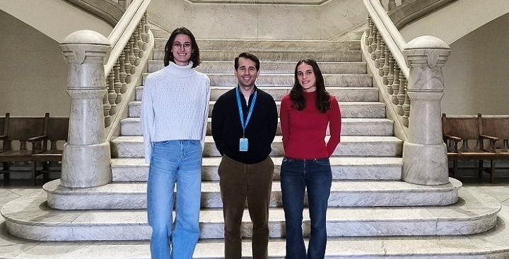 Three persons standing next to each other at the bottom of a marble imperial...