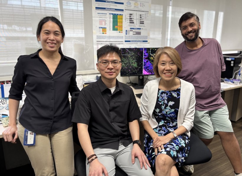 Four people sitting and standing in a laboratory office for a team photo
