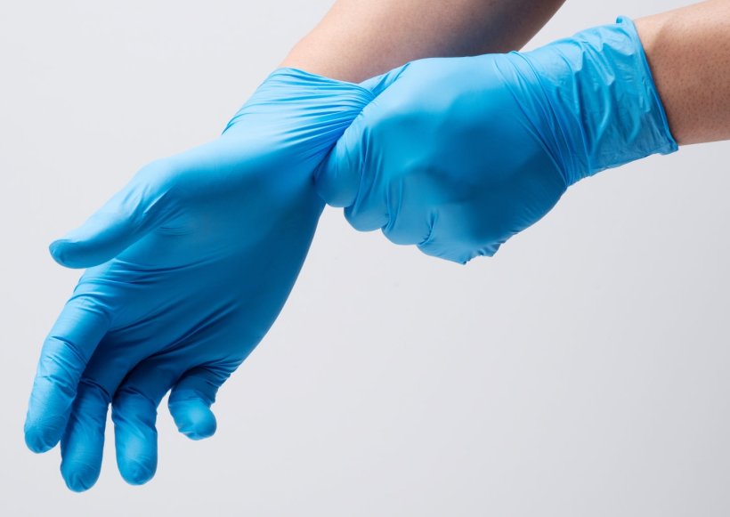 Der Bildausschnitt zeigt die Arme einer Person, die sich gerade blaue...