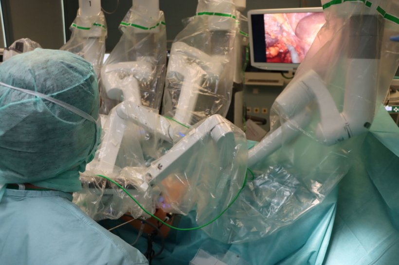 Chirurgen führen mithilfe eines OP-Roboters einen chirurgischen Eingriff an...