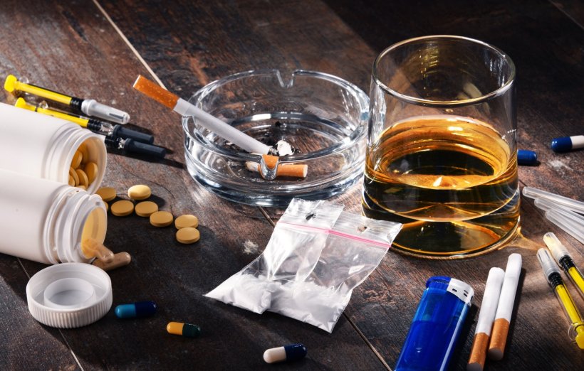 Assortment off addictive substances, like alcohol, various drugs, on a wooden...