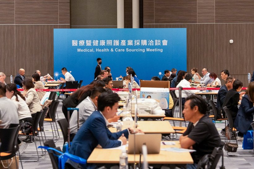 Many people are connecting and matchmaking at a medical tradefair. A blue sign...