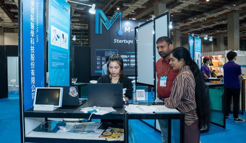 Three people engaging at the startup section of a medical tradefair