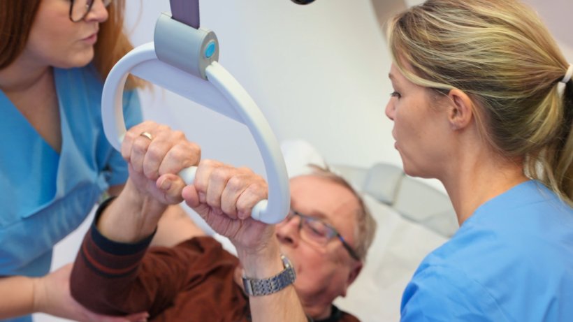 Closeup photo of a patient using a grip handle to get up from a hospital bed....