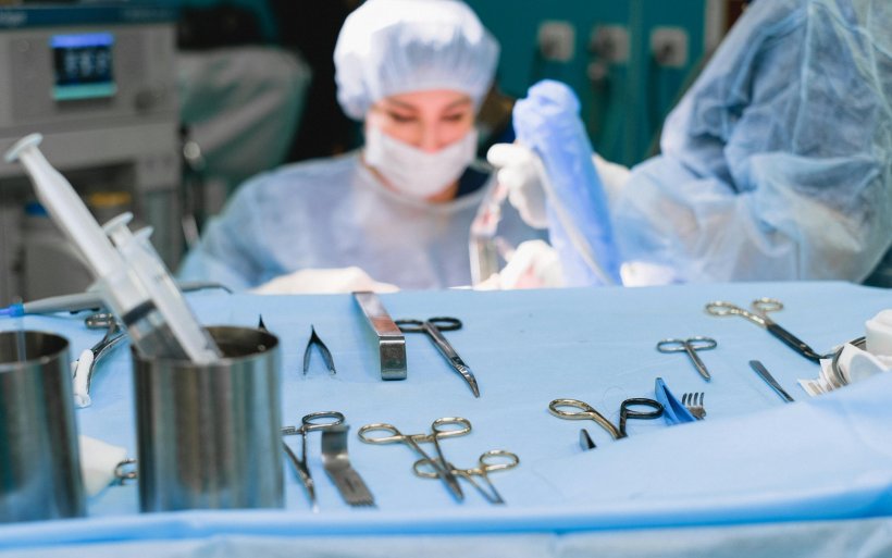 Mit blauem Tuch abgedeckter Tisch in einem Operationssaal mit OP-Instrumenten...