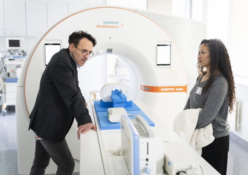 Prof. Hubertus Pietsch is standing next to a photon-counting CT scanner in a...