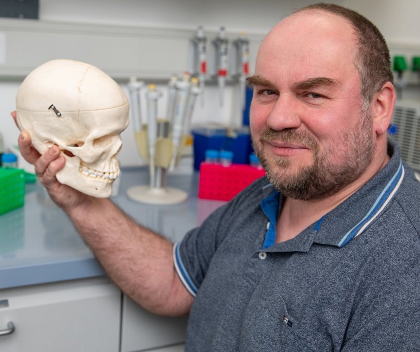 Prof. Dr. Christoph Garbers hält in einem Labor ein Modell eines Schädels in...