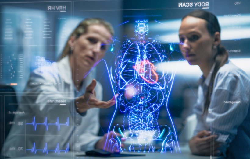 Two radiologists are looking at a 3D hologram of their patients thorax and...