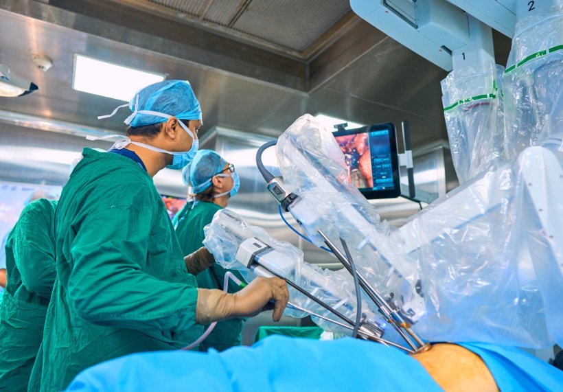 Zwei Chirurgen führen eine Operation mit einem Roboter-assistierten Verfahren...