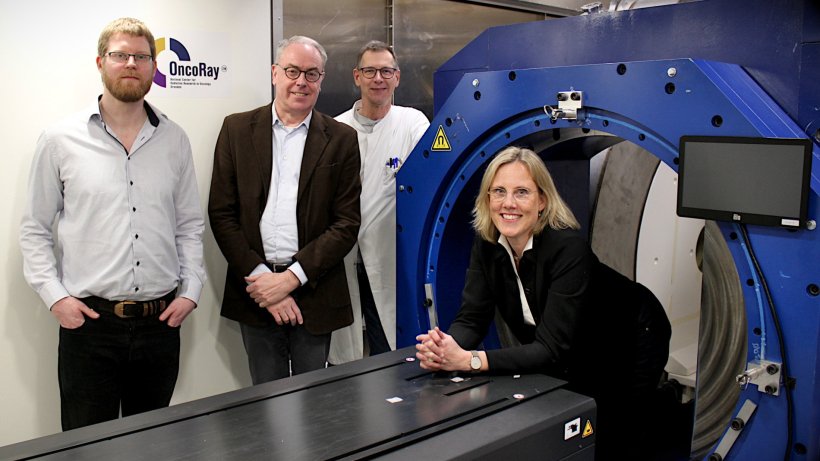 Vier Personen sind für ein Teamfoto um den blauen Prototypen eines...