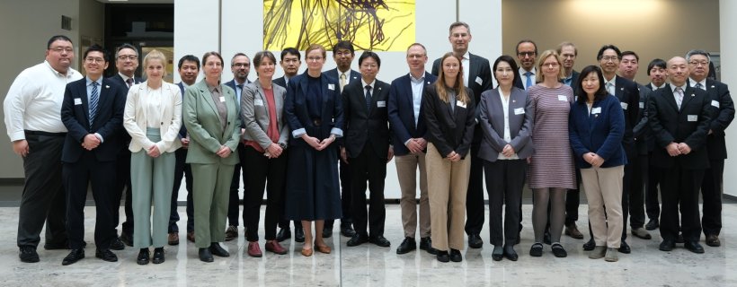 Gruppenfoto mit 25 Personen in der Eingangshalle eines großen Gebäudes mit...