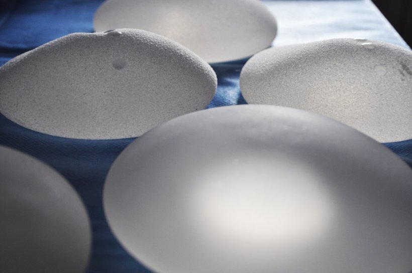 Fünf Brustimplantate auf einem blauen OP-Tisch