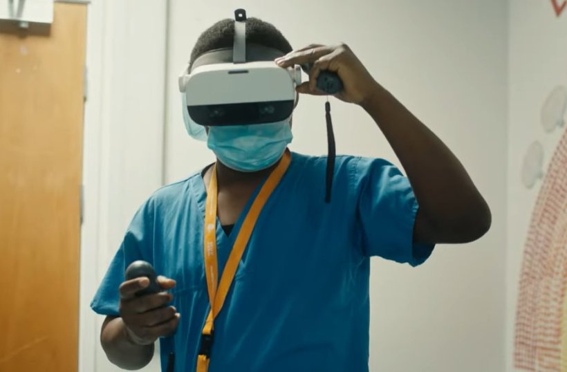 A medical professional in a blue surgical kasack is wearing a virtual reality...