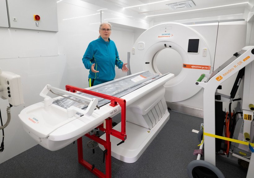 Eine Frau steht im Laderaum eines LKWs, der zu einem mobilen Diagnostik-Raum...