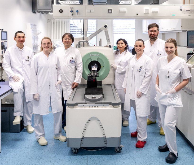 Teamfoto mit sieben Personen, die in einem medizinischen Forschungslabor um...