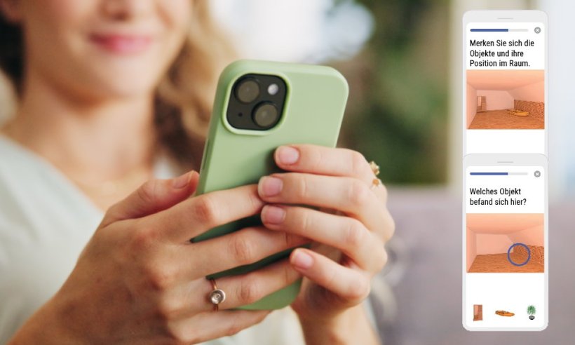 Eine Frau hält mit beiden Händen ihr Smartphone, das in einer lindgrünen...