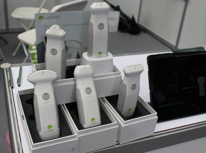 Five white ultrasound probes on display at a medical technology trade fair