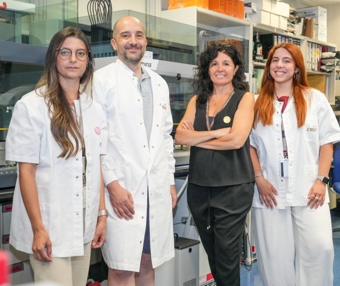 Four researchers are standing in a medical laboratory for a team photo
