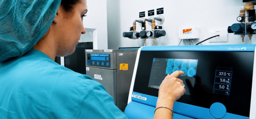 A medical professional is operating a device for checking cell health status in...