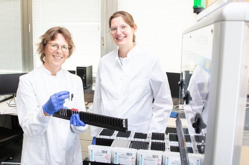 Birgit Bremer und Dr. Katja Dinkelborg stehen in einem medizinischen Labor an...