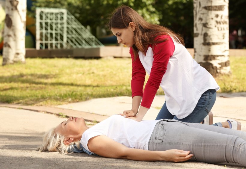 Eine Passantin leistet Erste Hilfe durch eine Herzdruckmassage bei einer...