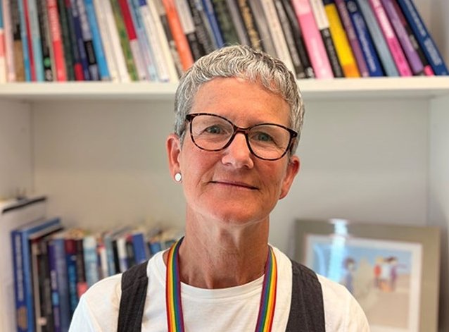 Portrait photo of Professor Nicola Mackintosh, in front of a shelf filled with...