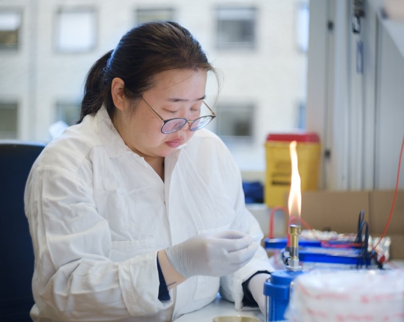 Bolor Buyanbadrakh is sitting at a table in a laboratory environment, looking...