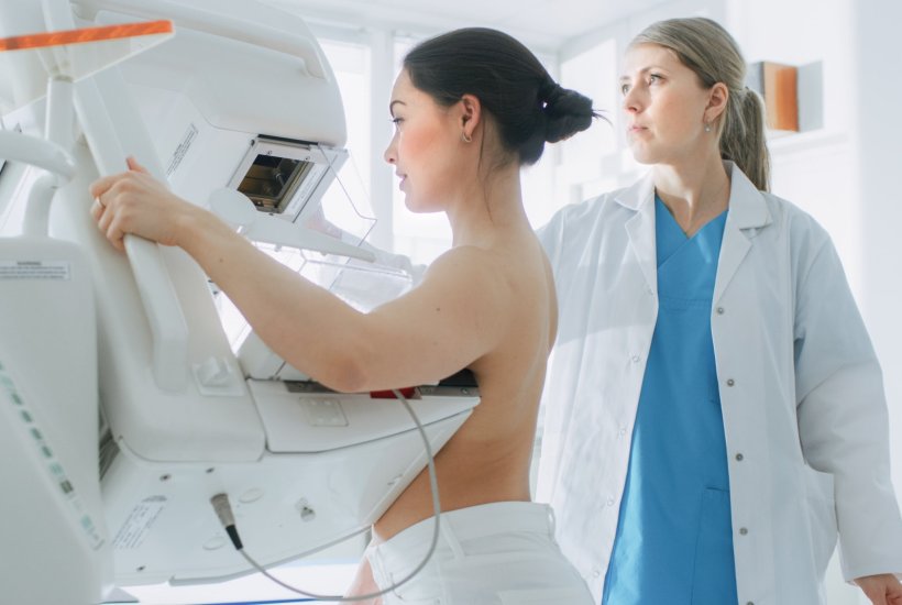 A young woman is undergoing breast cancer screening via mammography. The scan...