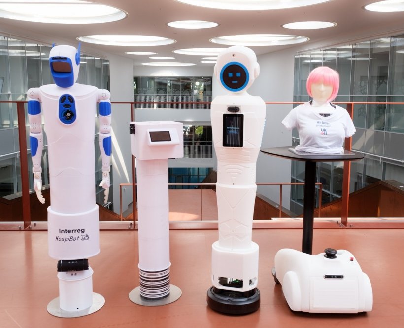 Vier weiße humanoide Roboter in verschiedenen Formen stehen nebeneinander vor...