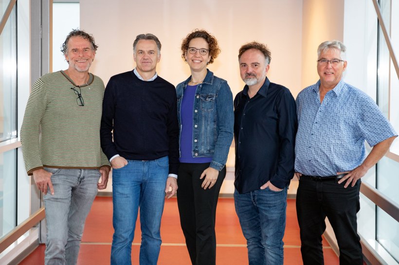 Fünf Personen stehen für ein Teamfoto nebeneinander in einem Krankenhausflur