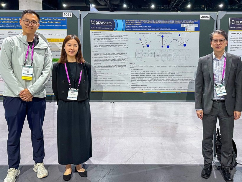 Three researchers are standing on either sides of their research poster