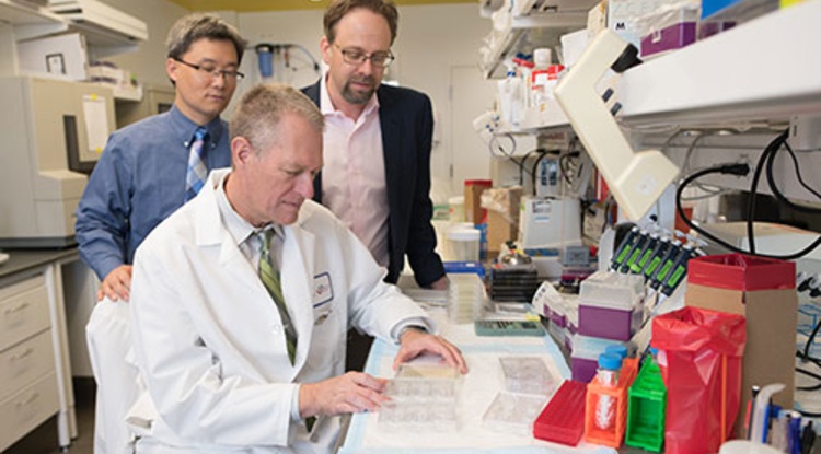 Frederic Zenhausern (seated) works with colleagues Dr. Kenneth Knox and Ting...