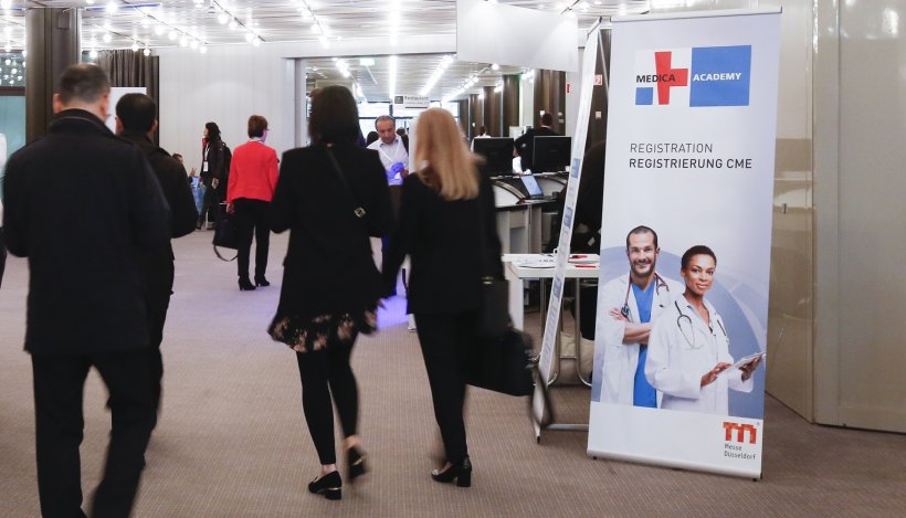 people walking towards a conference room at a medical fair