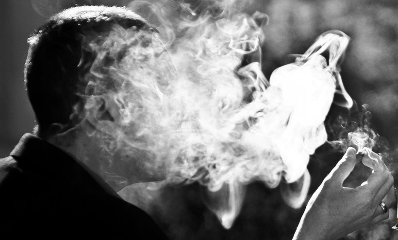 man exhaling smoke