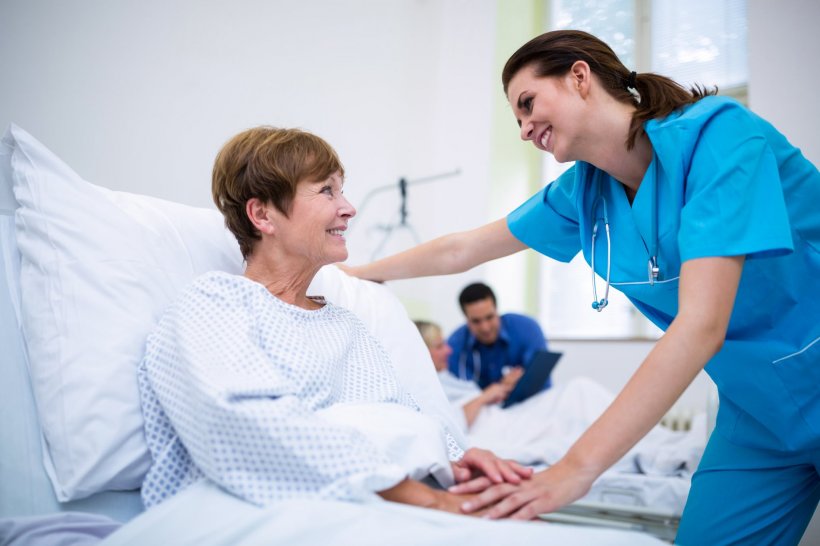 nurse consoling patient in hospital bed