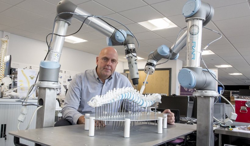 Philip Breedon demonstrating the two robotic arms for spinal surgery