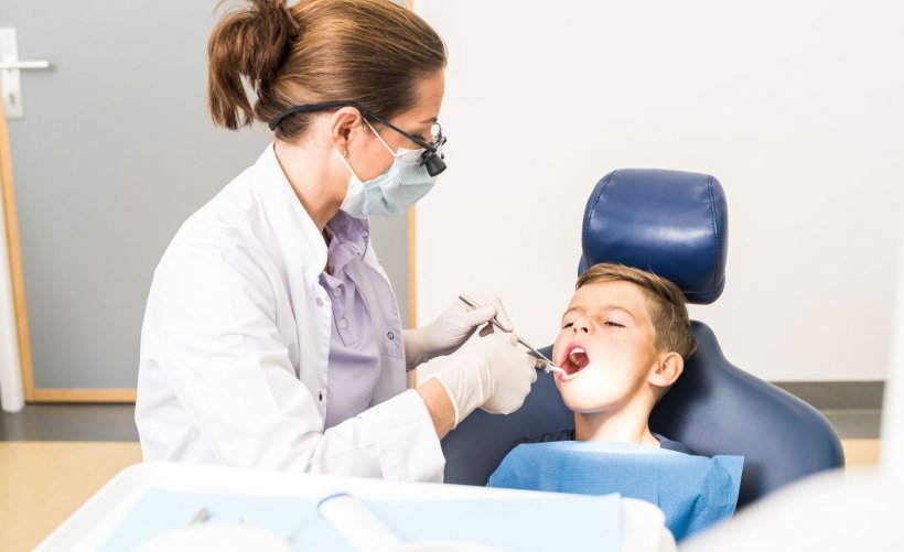 female dentist examining boy