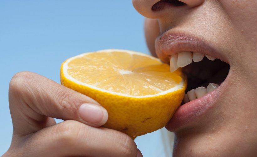 person biting an orange