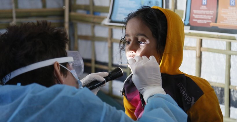 Paediatric nurse checks a girl for symptoms of diphtheria in Bangladesh