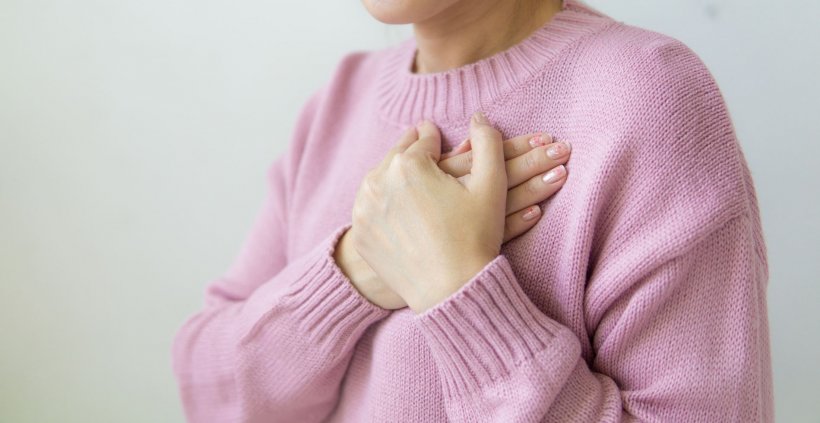woman in pink sweater with hands crossed in front of her chest