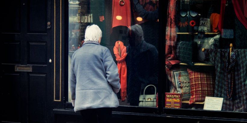 Person with grey hair looking at shop window
