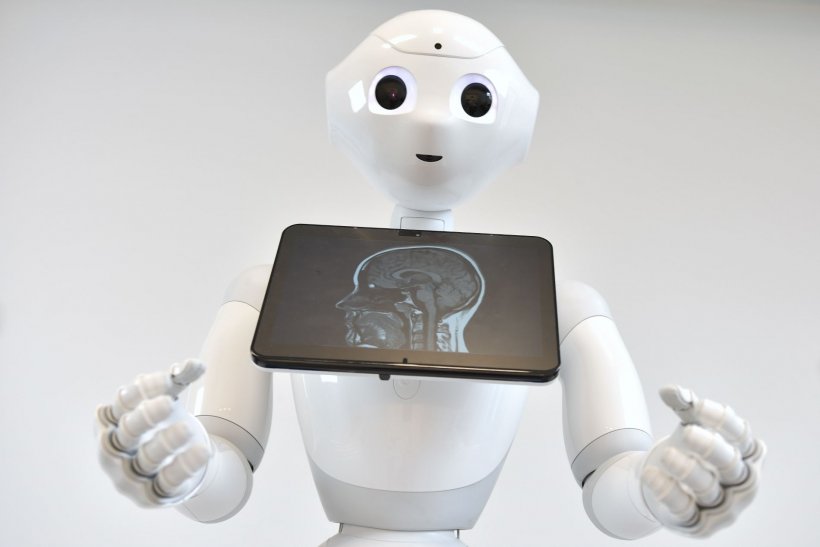 robot pepper holding a tablet device with MRI scan of a human head
