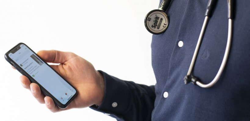 man with stethoscope holding smartphone