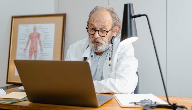 doctor in front of laptop giving telemedicine advice